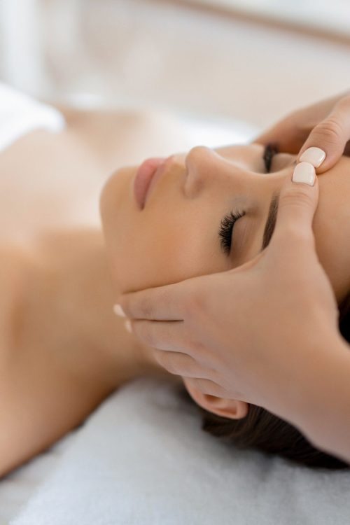 Calm girl having spa facial massage in luxurious beauty salon